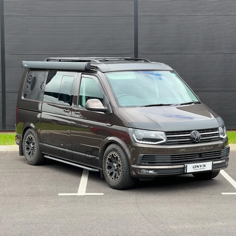 Brown VW Transporter with topographic contour-map graphics on its side panels
