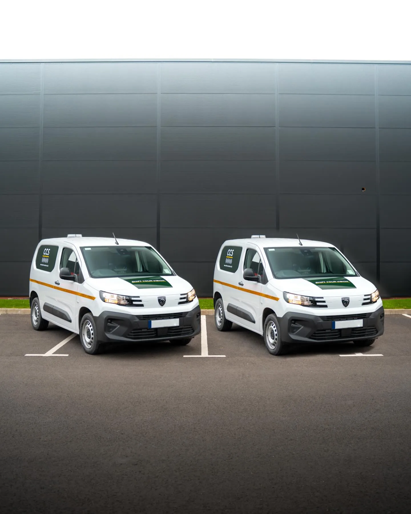Two white Peugeot vans with matching green and yellow Carter Ltd signwriting
