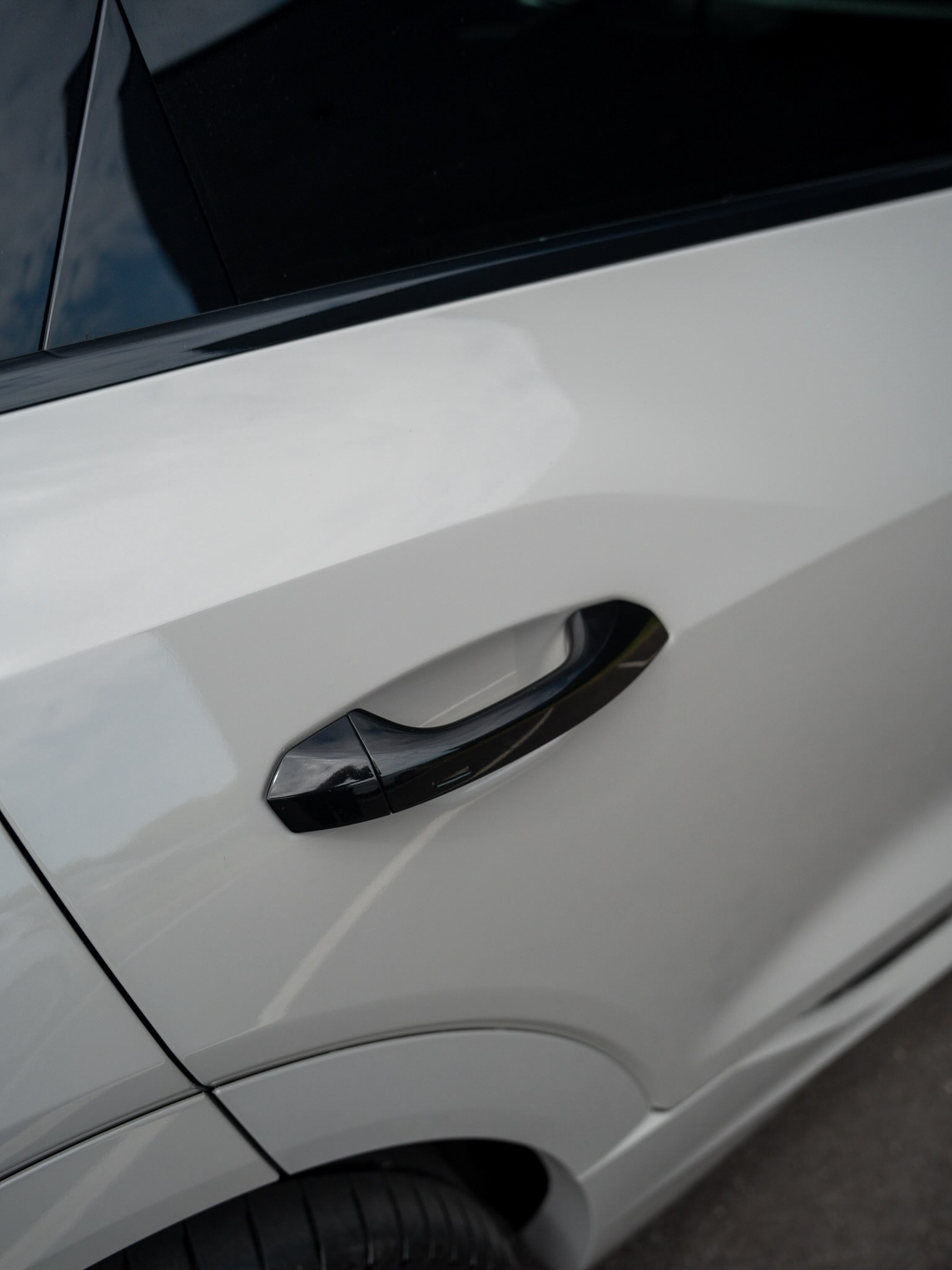 Close-up of the Crayon grey wrap around an Audi e-tron door and its black handle