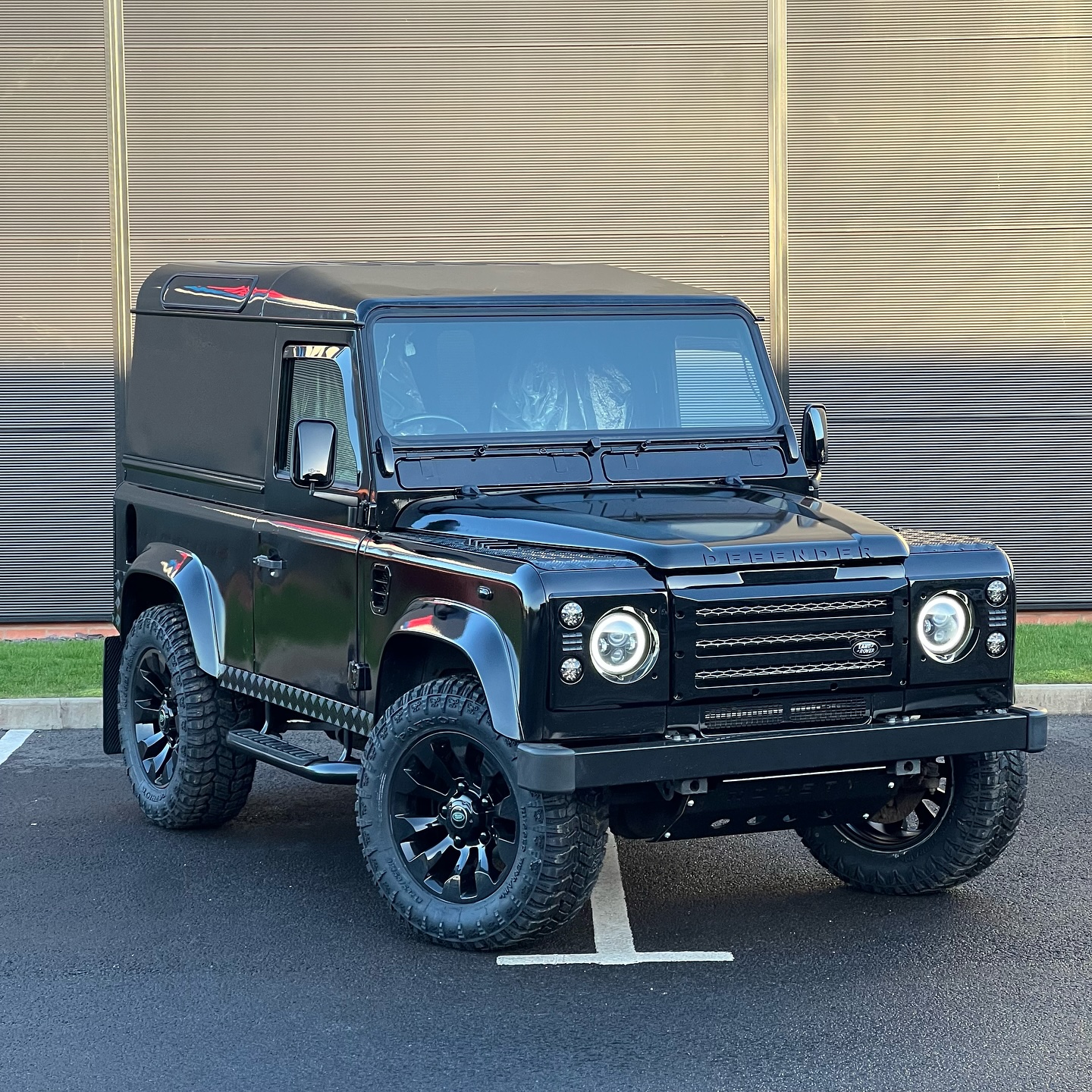 Black Land Rover Defender 90 TD5 with fitted side steps and bonnet lettering