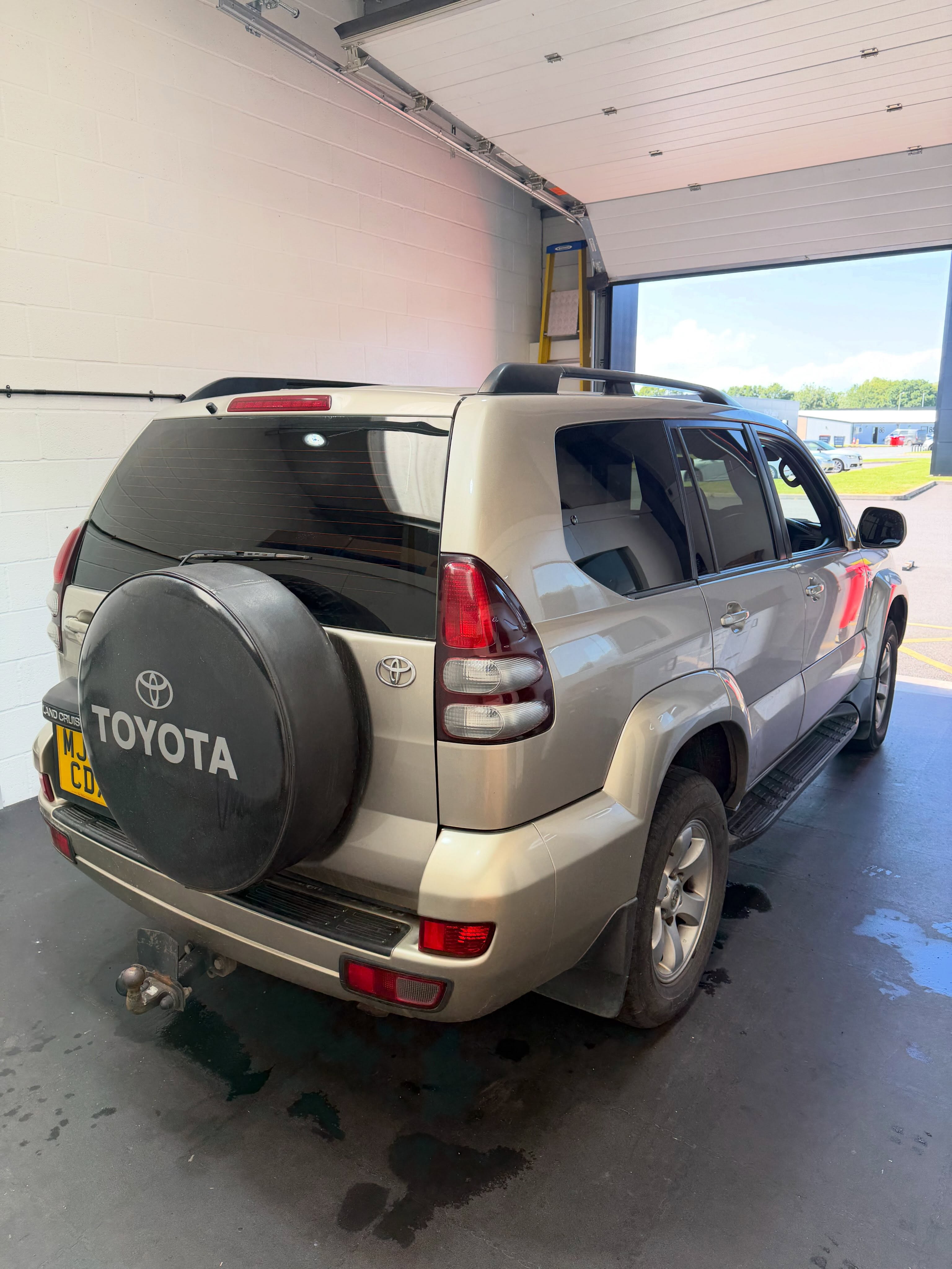 Toyota Land Cruiser 120 Series showing its 5% LLumar rear window tint from a rear three-quarter angle